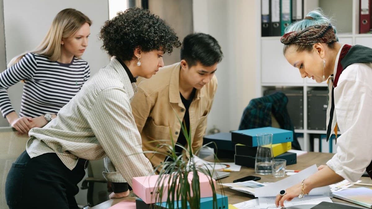 A team gathered around a table reviewing plans and materials together